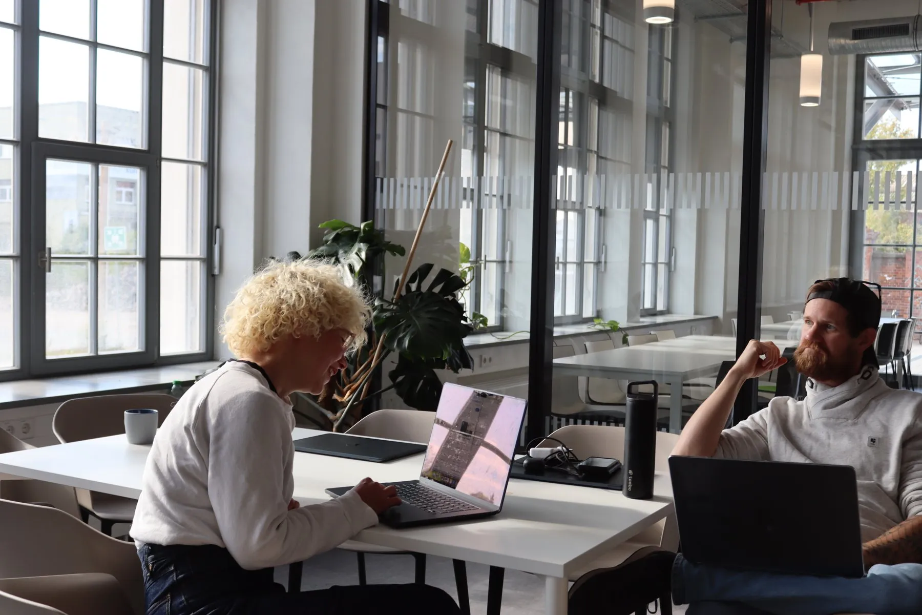 Zwei Kollegen arbeiten am Laptop im Büro in Leipzig