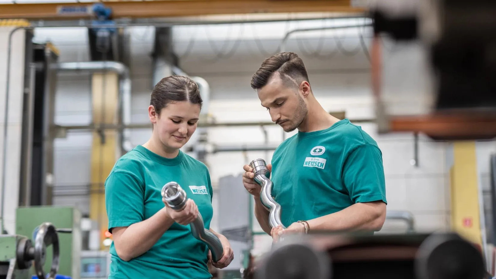 Two NETZSCH employees inspecting rotors in production